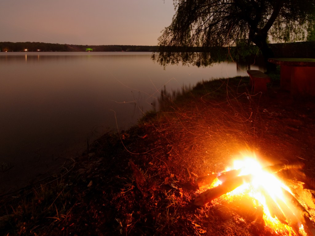 A campfire by a lake.